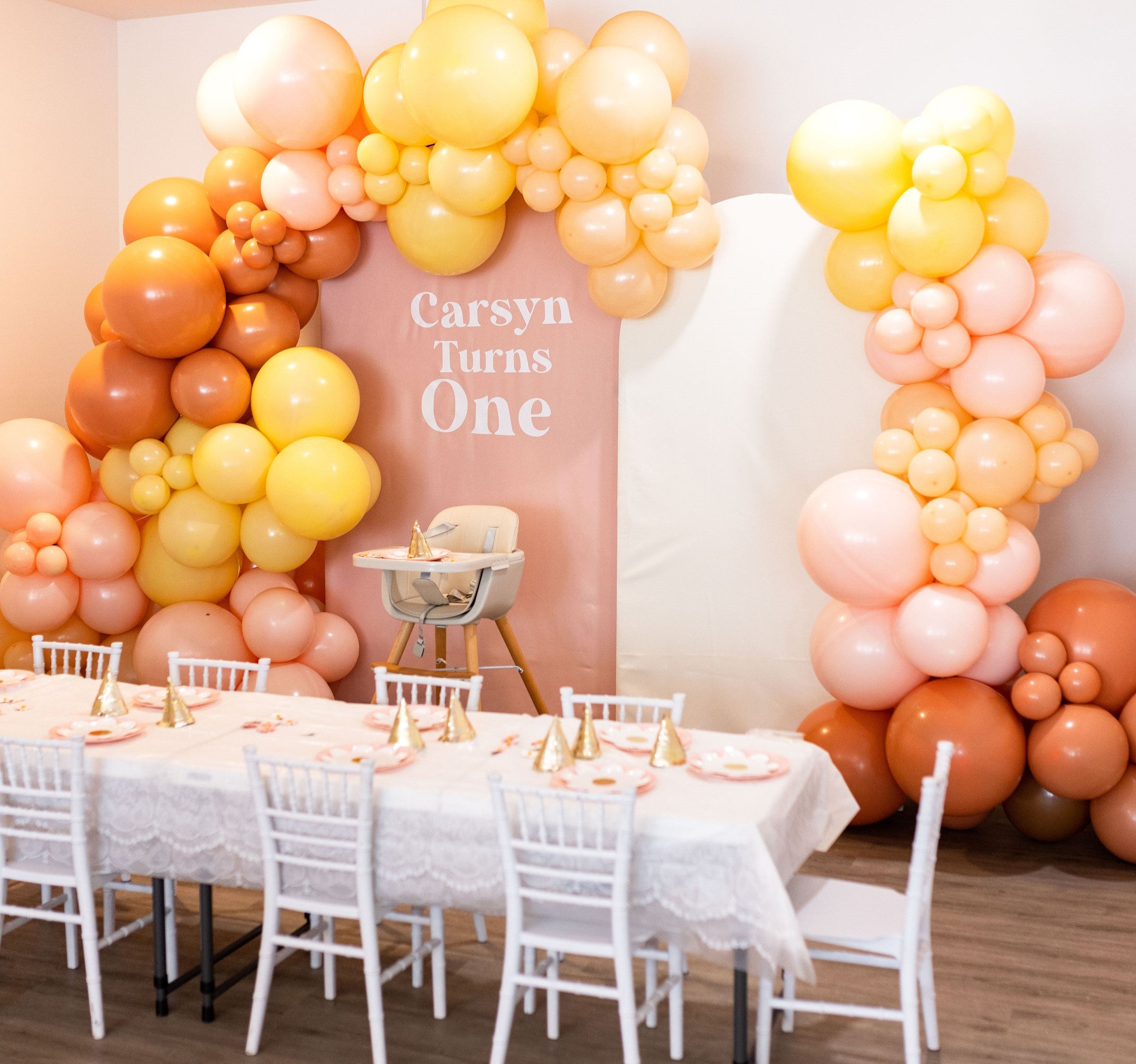 A charming boho-themed balloon garland, perfect for a little one's 1st birthday celebration, adding a whimsical touch to the party decor