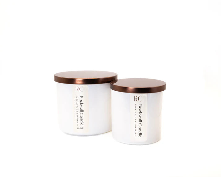 Two white candles with copper lids on a white background