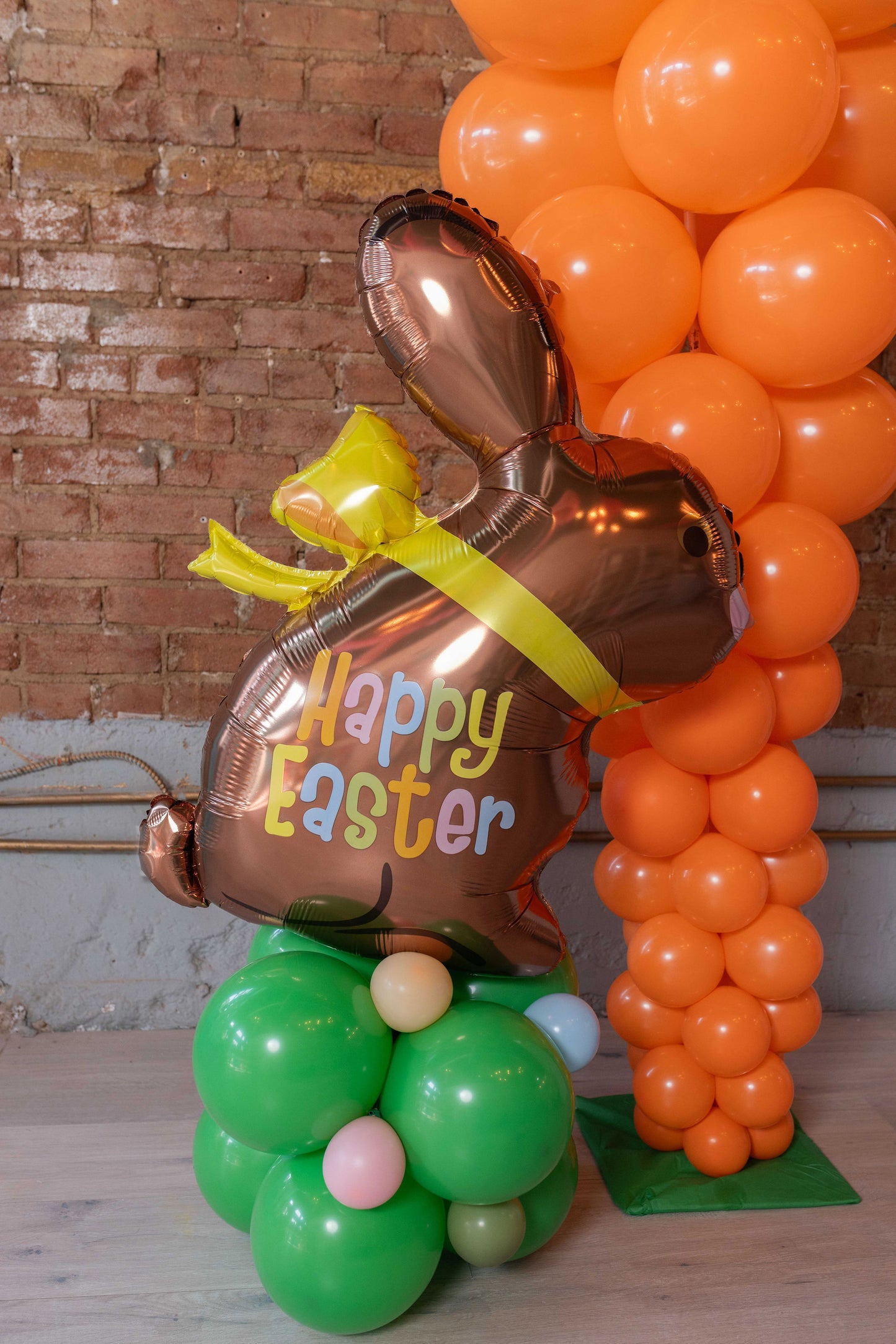Chocolate bunny foil balloon on stack of green balloons Easter balloons