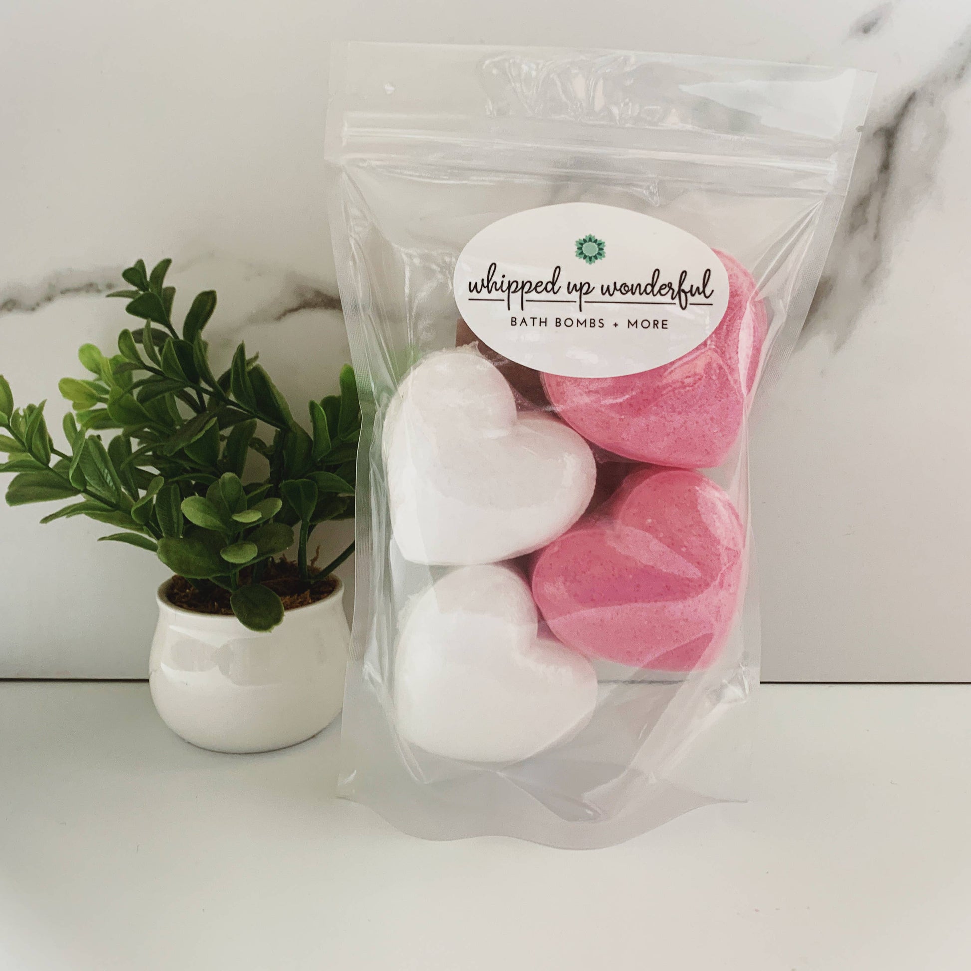 Packaged bath bombs with a plant in the background