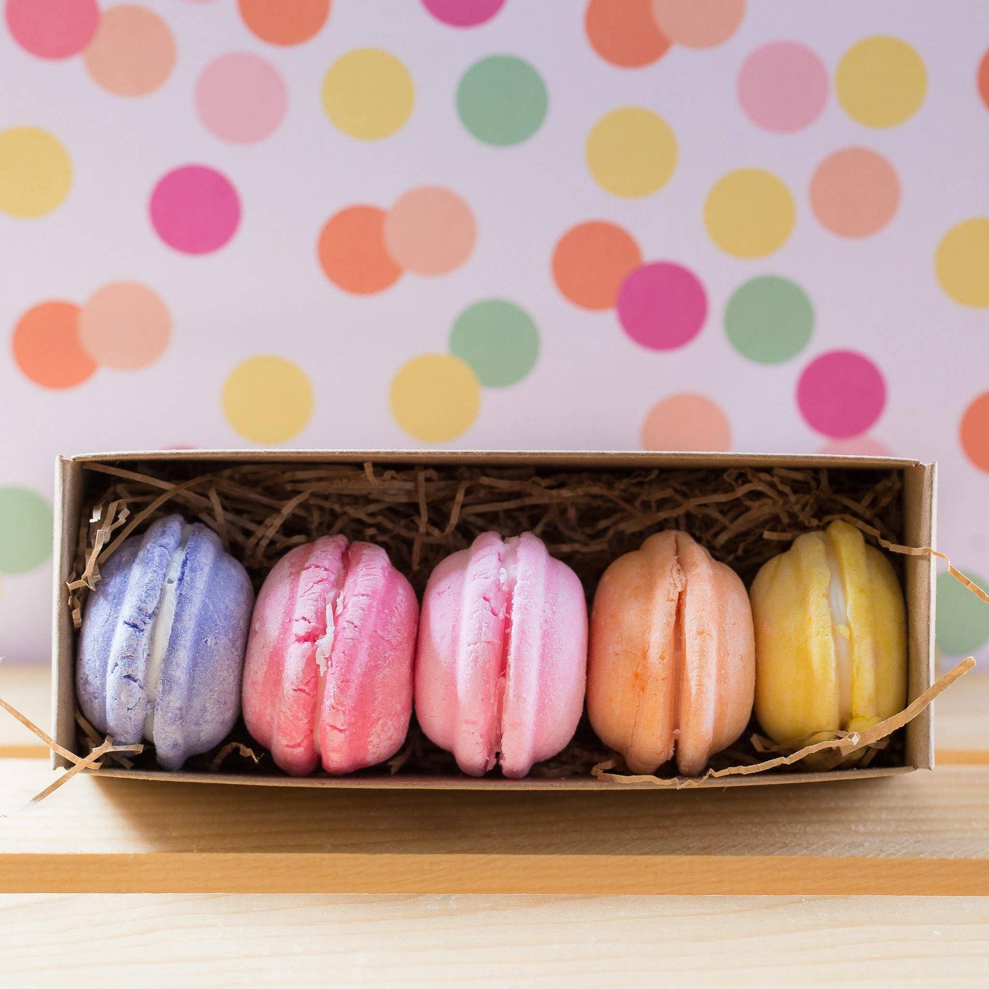 Box of colorful macarons on a polka dot background